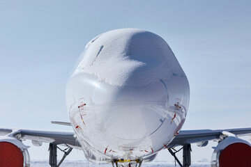 Snow covered cockpit of commercial airplane. Close-up view of plane after snowfall .