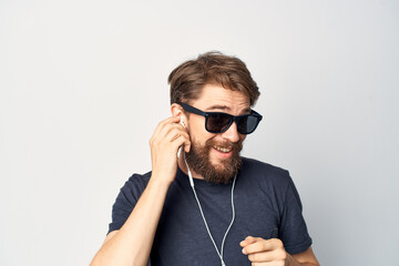 Cheerful man wearing glasses listening to music on headphones studio lifestyle