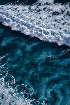 Aerial view to seething waves with foam. Waves of the sea meet each other during high tide and low tide