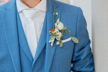 Groom in a blue jacket and beautiful flowers as a badge. Nice blue suit for wedding 
