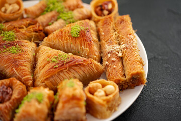 Delicious baklava dessert in oriental setting on black background