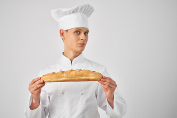 Cheerful male chef biting a loaf cooking food bakery
