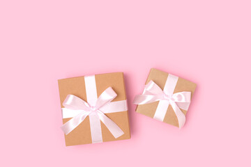 Gift boxes on a pink background. Present tied with ribbon. Festive concept with copyspace.