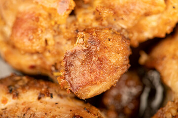 Fried pieces of meat in a frying pan, close-up, selective focus.