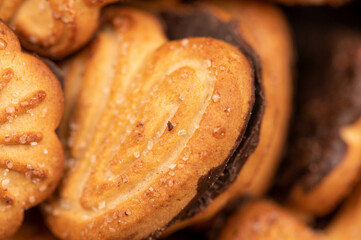 Curly cookies covered with chocolate icing, background image, close-up, selective focus.