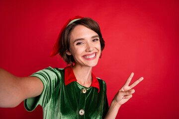 Photo of positive influencer lady show v-sign shoot selfie wear elf costume hat isolated red color...