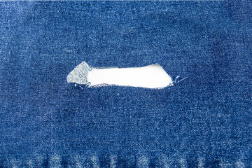 Destroyed ripped denim blue jeans fabric frame on white background. Place for text. denim...