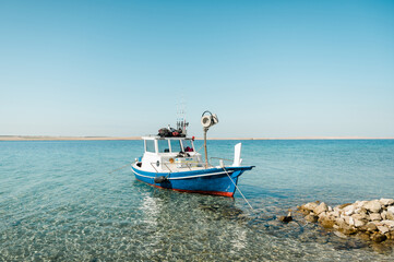 Naklejka na ściany i meble Fishing boat next to the beach in Croatia. Beautiful summer day, crystal clear water.