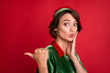 Photo of surprised lady direct thumb empty space palm cheek open mouth wear elf costume hat...