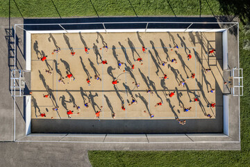 Male and female athletes playing basketball at sports court