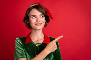 Photo of dreamy adviser lady direct finger empty space look up wear elf costume hat isolated red...