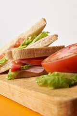 Sandwich with tomato an lettuce, wood board table