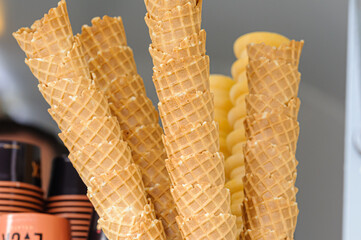 Waffle cones stacked up on the counter of an ice-cream shop.