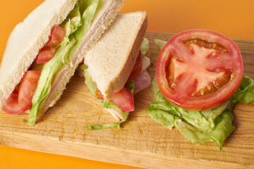 Healthy sandwich with tomato in orange background