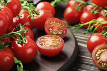 Composition of fresh ripe branches of cherry tomatoes, thyme, basil, rosemary, spices on a wooden textured background