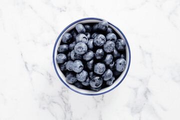 composition of ripe blueberries on a textured marble background