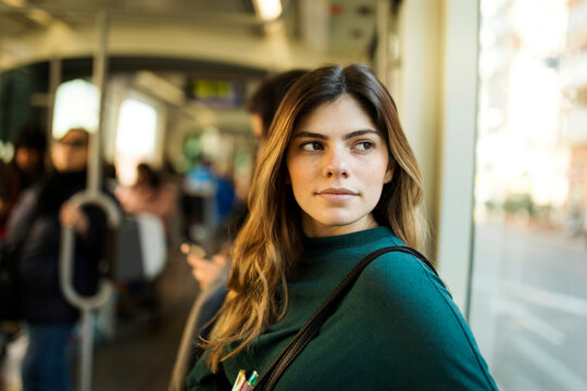 Young woman looking through window while travelling in tram