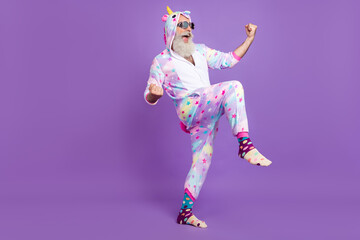 Full length body size view of attractive cheerful man in pajama rejoicing isolated over violet...