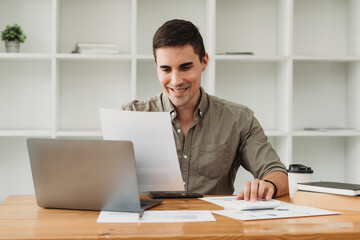 Businessman in shirt working on his laptop in an office. Open space office