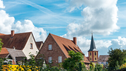 Old German houses and church under a sunny cloudy sky. Ilvesheim, Germany