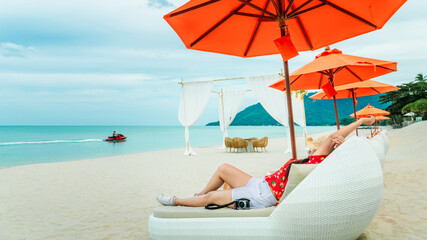Summer lifestyle traveler woman relax on beach chair in front of vacation exotic Khanom beach,...