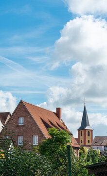 Old German houses and church under a sunny cloudy sky. Ilvesheim, Germany