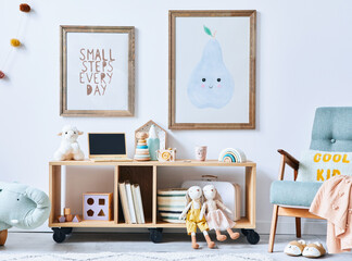 Cozy interior of child room with mint armchair, brown mock up poster frame, toys, teddy bear,...