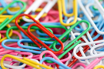 Lots of multi-colored paper clips of same size on table.