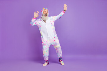 Full length photo of old crazy dreamy man wear pajama good mood look empty space isolated on purple...