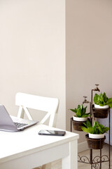 Freelancer's working place at home. Minimal background image of clean home office interior with wooden desk and laptop.