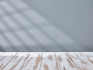White table top and gray wall with light from the window