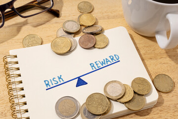 Risk reward concept. Drawing on notepad and coins on desk