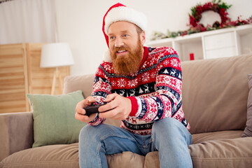 Photo of smiling guy sit sofa couch having fun free time relaxing at home celebrate winter vacation new year play playstation © deagreez