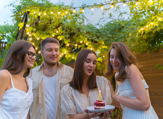 Birthday party with friends. Make a wish. Birthday cake with candle. Anniversary celebration