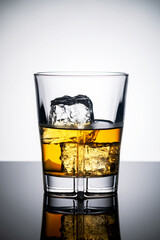 glass of whiskey with ice on white background
