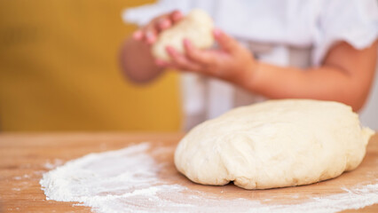 Children's hand making cookies. Little cute girl in preparing cookies for christmas.