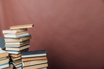 Stacks of books for teaching college library knowledge brown background