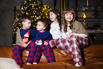 Obraz na płótnie Canvas Portrait of children wearing in pajamas celebrating christmas at home together 