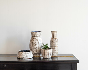 Mid-century modern pottery, grey vases and pots on a black furniture isolated