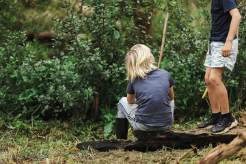 Boy sitting on log in Australian bush