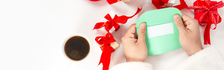 Santa Claus opening a letter and preparing for Christmas with decorations, gifts, top view. Banner