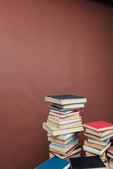 Stacks of books for teaching college library knowledge brown background
