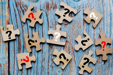 wooden puzzles with a question mark. copy space. blue background