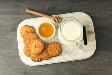 Milk, honey and pumpkin cookies on gray wooden table