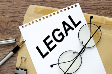 legal . text on white paper on craft envelope on wood background