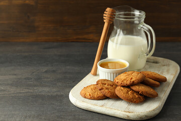 Milk, honey and pumpkin cookies on gray wooden table