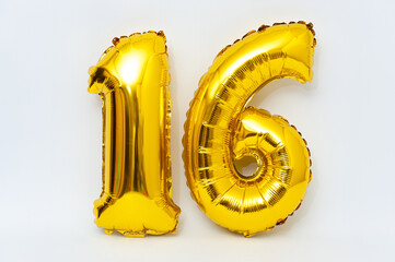 Inflatable numeral 16 sparkling metallic golden color isolated on white background. Close-up.