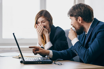 business man and woman sitting at a desk with a laptop communication professionals