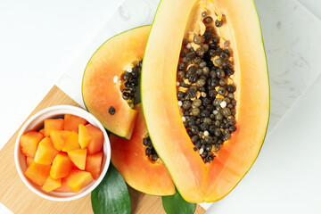 Board with ripe papaya on white background