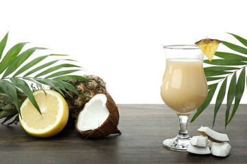 Pina colada cocktail and ingredients on wooden table, isolated on white background